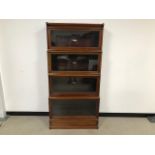 A set of four wooden and glazed library bookcases by Globe-Wernicke Co Ltd, with base and cornice,