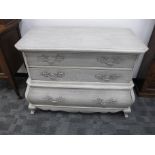 A contemporary Louis XV style bombe commode, three long drawers, distressed limed finish, possible