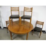 A Mid - Century teak veneered dining table and chairs, circular drawer leaf table with pop up