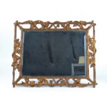 An early 20th Century mirror in carved giltwood frame taking the form of vines and grapes, with