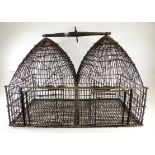 A double sided metal bird cage of twin dome form, approximate dimensions 48cm x 65cm x 32cm