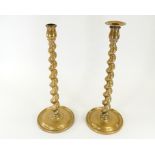 A pair of brass barley twist candlestick holders, the bases with impressed registration numbers,