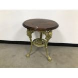 A vintage café table, cast iron gilt painted base with circular wooden top, 58cm diameter x 70cm