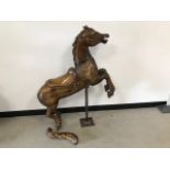 A carved wooden horse, similar to that from a fairground ride, tail broken off, with a steel