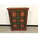 A vintage Indian cabinet, the two panel doors, sides and top all painted with flowers, 91cm wide,