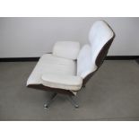 A vintage Eames style swivel armchair, veneered oak frame, faux white leather upholstery and