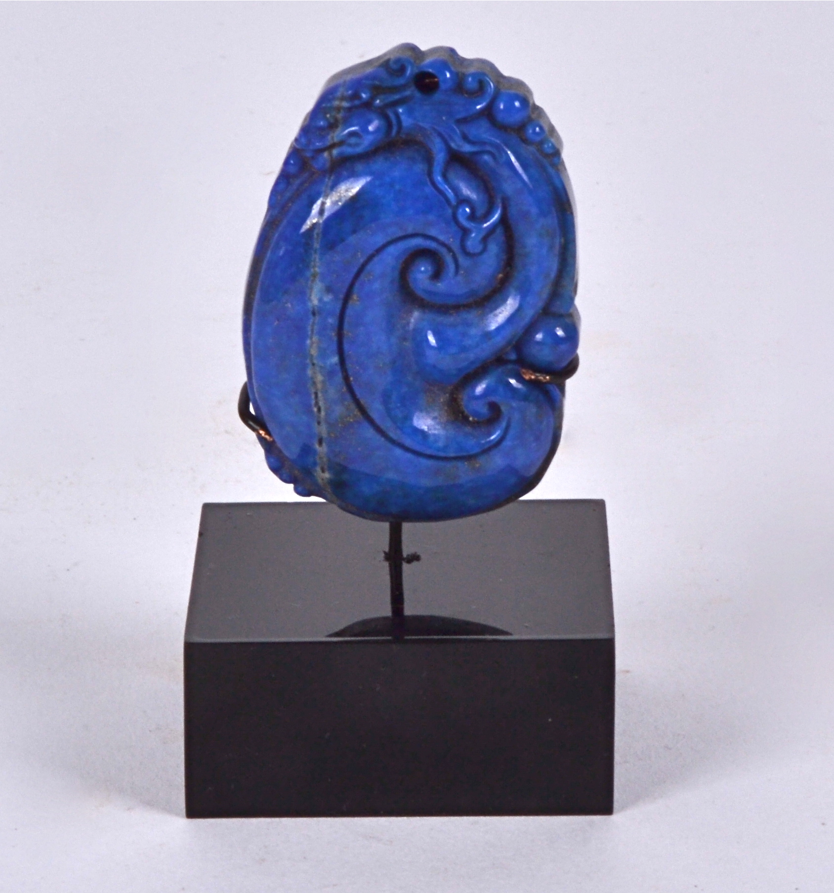 A Lapis Lazuli block mounted on contemporary stand, taking the form of a coiled chilong dragon,