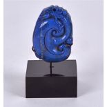 A Lapis Lazuli block mounted on contemporary stand, taking the form of a coiled chilong dragon,