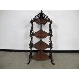 A Victorian mahogany floor standing four tier corner whatnot, pie crust moulded edges to shelf