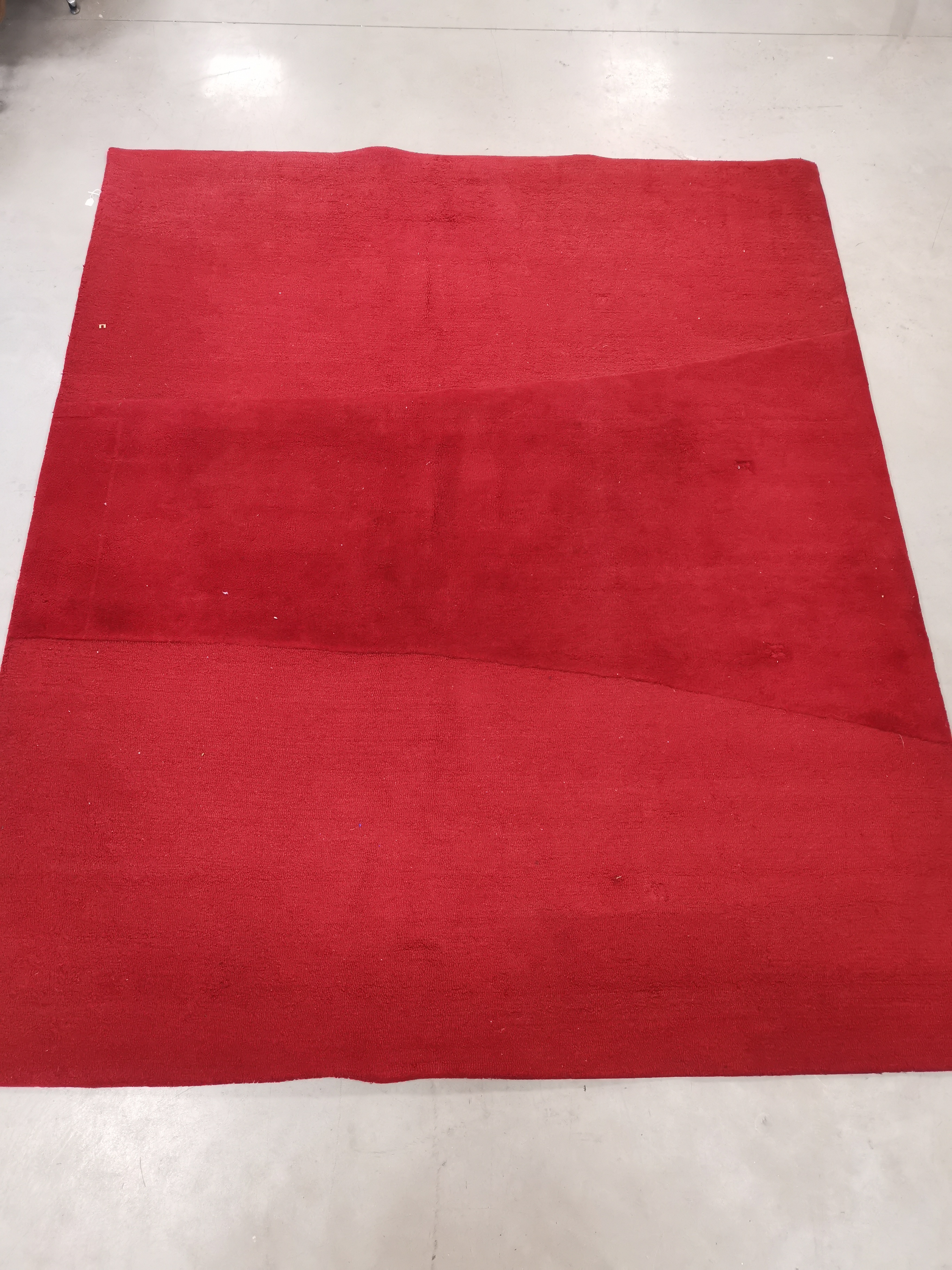 A bespoke woollen red ground rug, the verso with label 'Kappa Lambda Rugs London design Custom