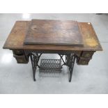 A vintage American Singer treadle sewing machine, housed in kneehole oak case with two short drawers