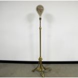 A Victorian extendable brass standard lamp, tripod base, fitted with large modern bulb with a spiral