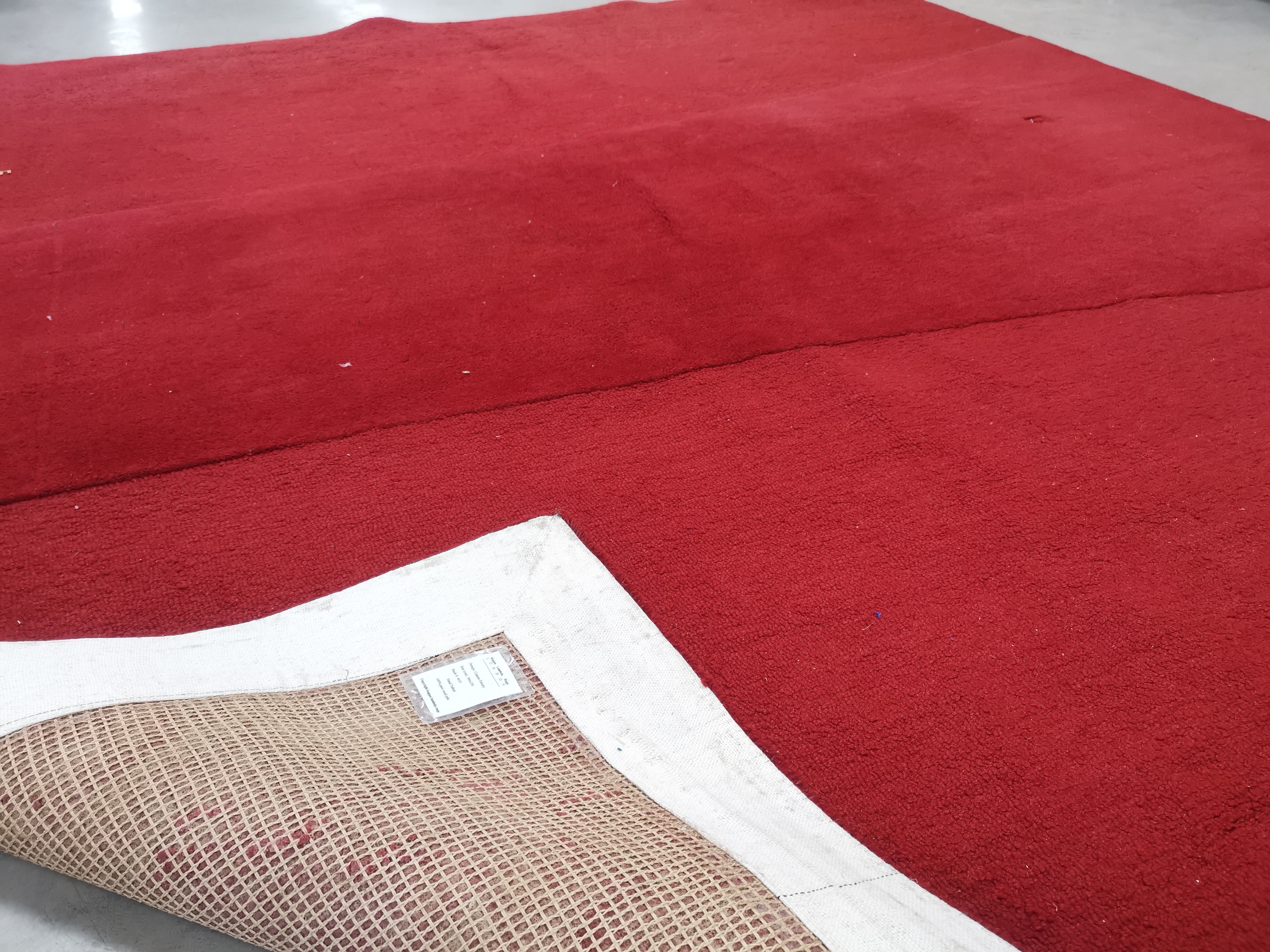 A bespoke woollen red ground rug, the verso with label 'Kappa Lambda Rugs London design Custom - Image 2 of 3