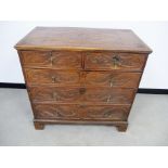 An 18th Century oak chest, of two short over three long graduated drawers, later carving to panelled