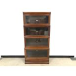 A set of four wooden and glazed library bookcases by Globe-Wernicke Co Ltd, with base and cornice,