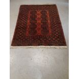 Old Middle Eastern Rug, a bordered geometric patterned red ground example with ten octagonal