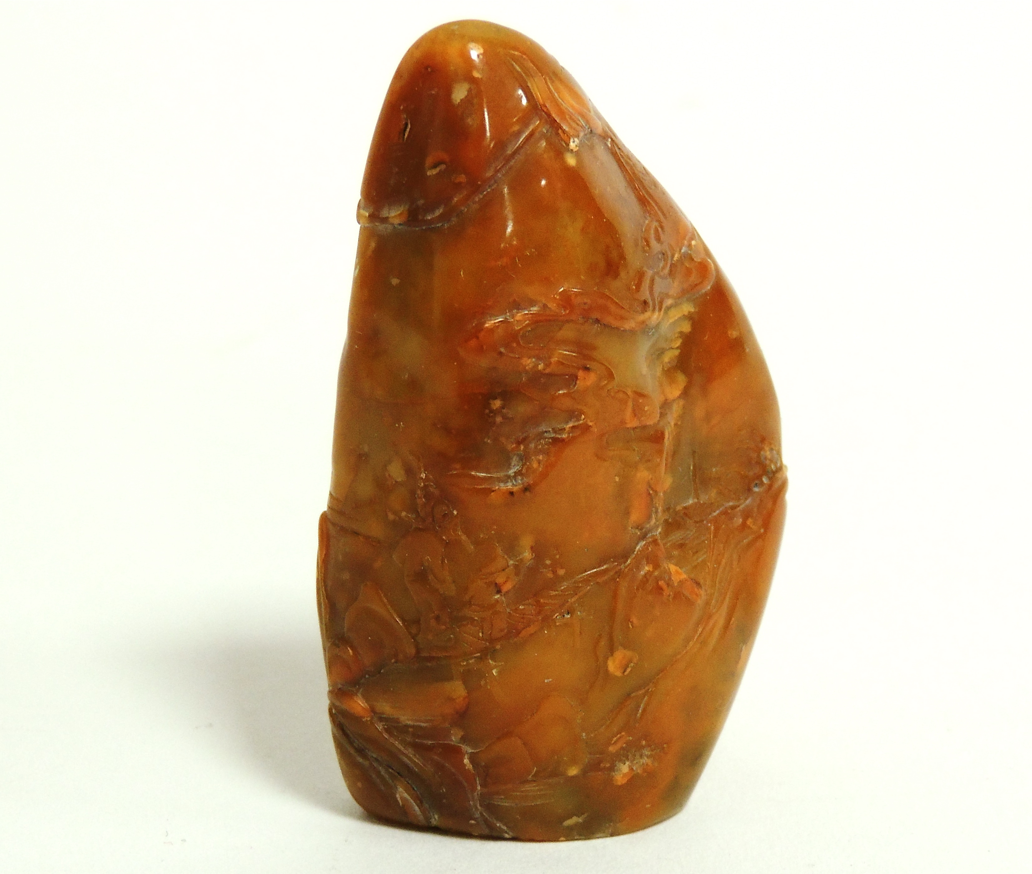 A Chinese Jadeite carving of near arrow head shape, with carved figures in a continuous