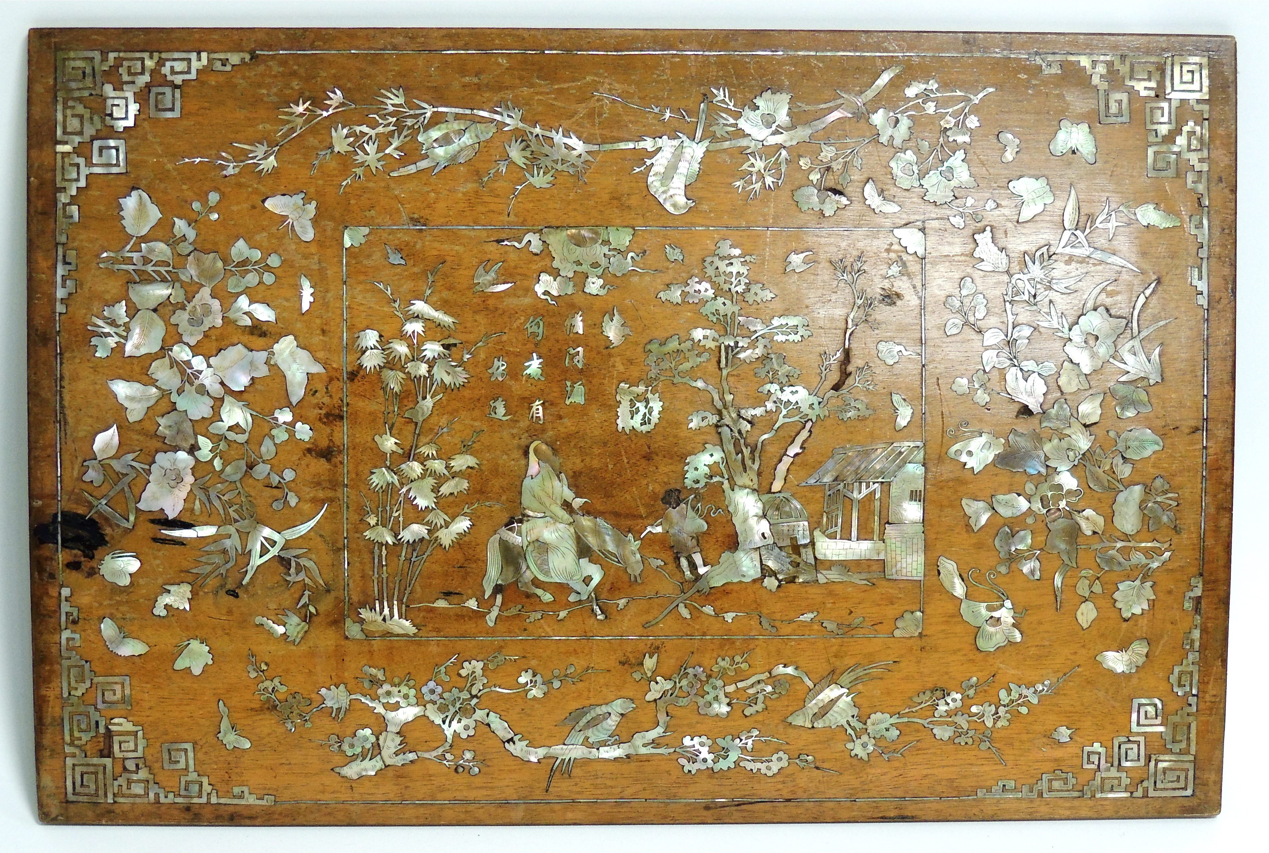 A Chinese wooden panel with inset mother of pearl, depicting a figure riding a horse, quite possibly