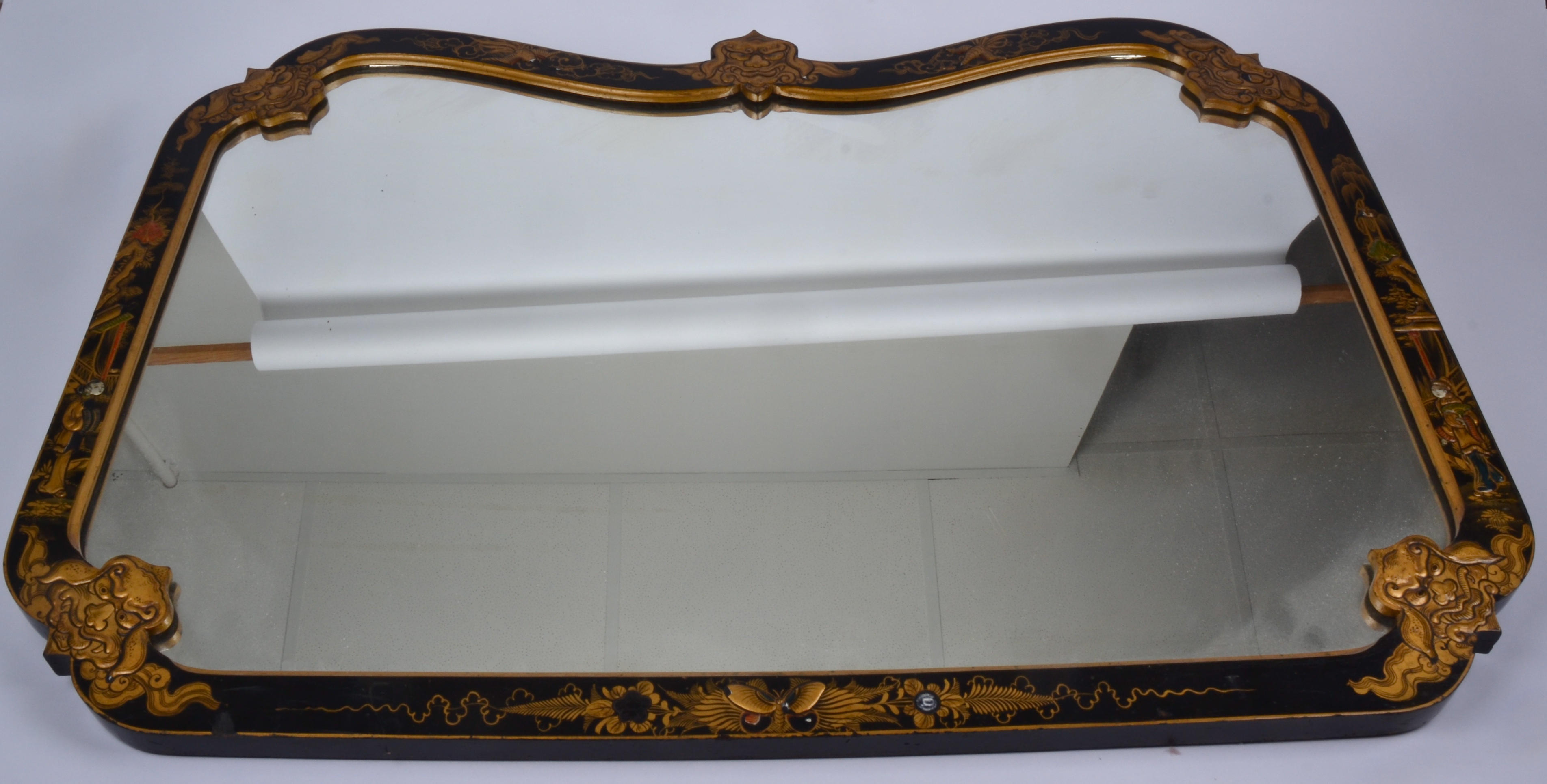 An early 20th Century Chinese wall mirror, the japanned frame with five raised Dogs of Fo heads,