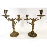 A pair of 19th Century brass candlestick holders taking the form of angels raising torcheres, the