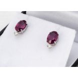 A pair of platinum ruby and diamond ear studs, the oval mixed cut rubies surmounted by brilliant cut