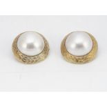 A pair of 14ct gold mabe pearl clip earrings, with textured tapered mounts marked 585 to reverse,