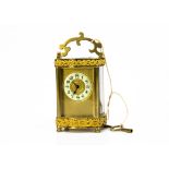 An early 20th Century French brass carriage timepiece, enamel dial, appears to run, with C scroll