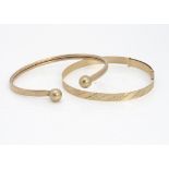 A 9ct gold torque bangle, 6cm x 5cm and another adjustable bangle with engraved star design, 7cm