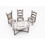 A late Victorian continental silver miniature dining table and pair of chairs by JBL, the table