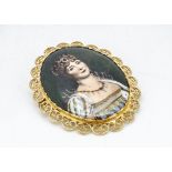 A continental yellow metal filigree mounted oval brooch, with transfer printed porcelain plaque