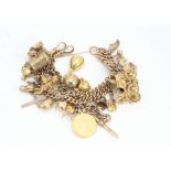 A 9ct gold large double chain curb linked charm bracelet, with multiple gold charms, mostly 9ct,