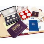 A collection of coins and stamps, including two 1976 Canadian Olympics four coins silver proof sets,