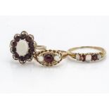 Two 18ct gold garnet dress rings, one set with white opals and rough cut diamonds centred with a