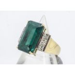 An Art Deco style diamond and synthetic emerald dress ring, the central claw set emerald cut stone