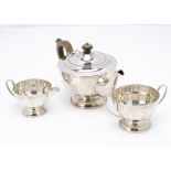 A George V silver three piece tea set by H.C Co, teapot with applied brown Bakelite style handle and