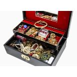 A collection of costume jewellery, in black hinged cantilevered jewellery box including brooches,