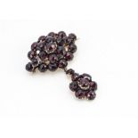 A 19th Century mixed cut garnet brooch, of oval shape with suspended drop pendant, 3.5cm x 4.5cm,