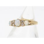 An 18ct gold opal and diamond dress ring, the three cabochon opals alternately set with pairs of