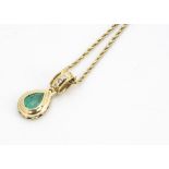 An emerald and diamond 18ct gold pendant and chain, the pear shaped emerald in rubbed over stepped