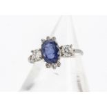 An 18ct gold sapphire and diamond dress ring, the oval mixed cut sapphire in four claw setting