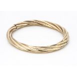 A 9ct gold rope twist hinged bangle, with hollow core, tongue and box clasp, marked to clasp 9k