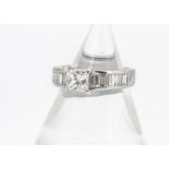 A continental 18ct white gold princess cut solitaire diamond, with baguette channel set shoulders,