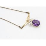 A 9ct gold amethyst and cultured pearl pendant and chain, mixed cut oval claw set amethyst within