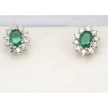 A pair of emerald and diamond cluster ear studs, the oval mixed cut emeralds surrounded by brilliant