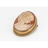 A 9ct gold and shell cameo oval brooch or pendant, the carving depicting the profile of a young girl