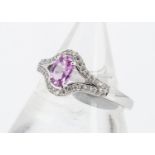 A pink sapphire and diamond dress ring, the oval mixed cut in white 18ct gold with diamond set bezel