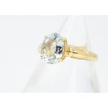 An 18ct gold aquamarine dress ring, the oval cut aquamarine in four claw setting on a gold shank,