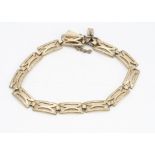 A continental yellow metal rectangular pierced link bracelet, with textured clasps and safety chain,