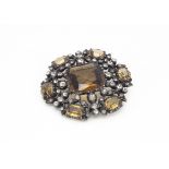 A late 19th/early 20th Century paste set simulated smoky quartz brooch of circular design set in