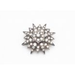 A pre War diamond platinum set star brooch, the eight ray star alternating between smaller rays